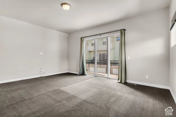 Sliding glass door, wall-to-wall carpeting, and flush mount ceiling light