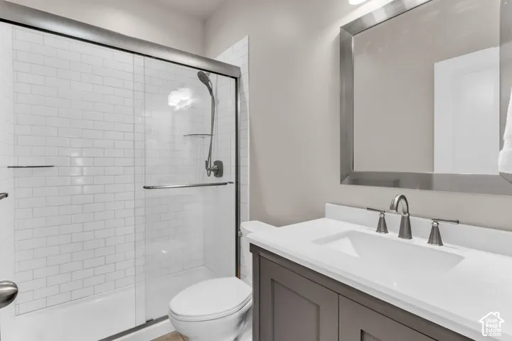White subway tile shower with a sliding glass door and handheld showerhead