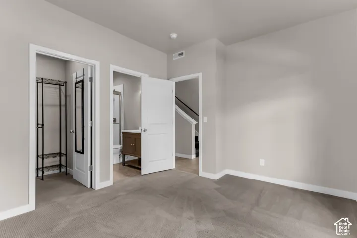 Carpeted room featuring light-toned walls
