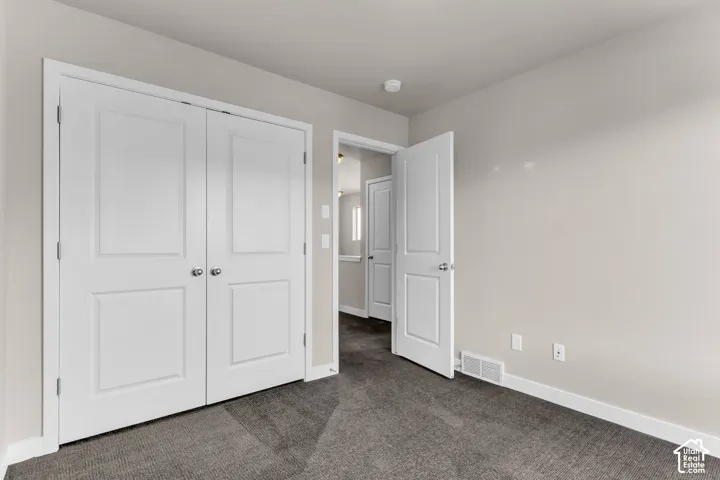 Textured carpeting, white trim, and a paneled door