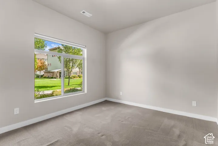 Expansive window, neutral wall paint, and gray carpet