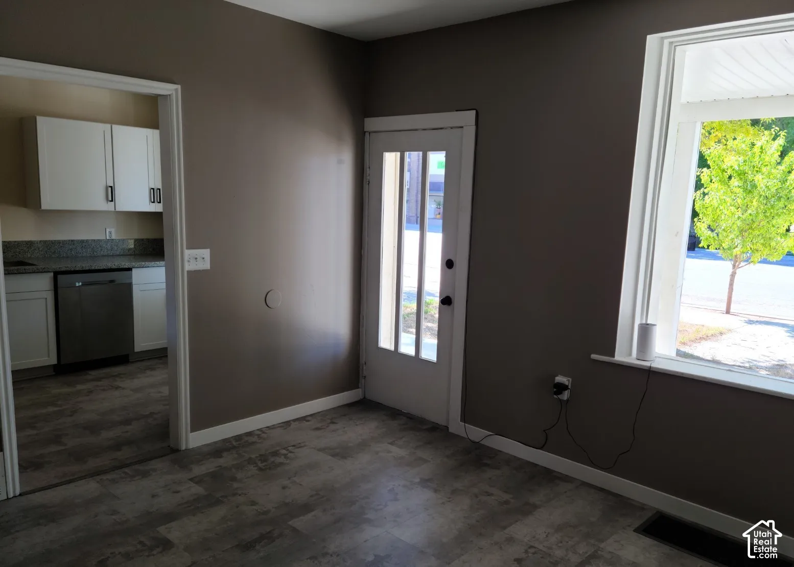 Wood-finish flooring throughout, white trim, and a glass-paneled door