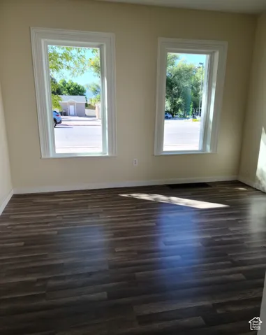 Wood-finish flooring and two windows with white trim