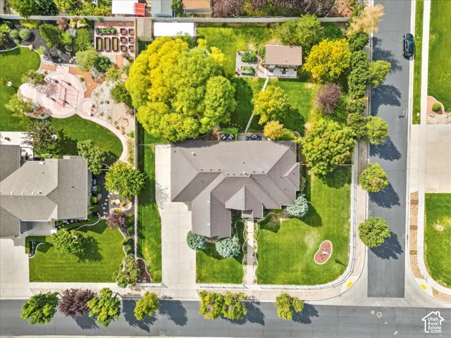 Expansive property featuring a large residence with a multi-gabled roof, extensive lawns, and mature trees