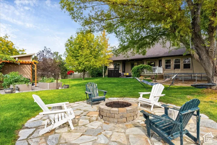 Stone paver patio featuring a built-in fire pit