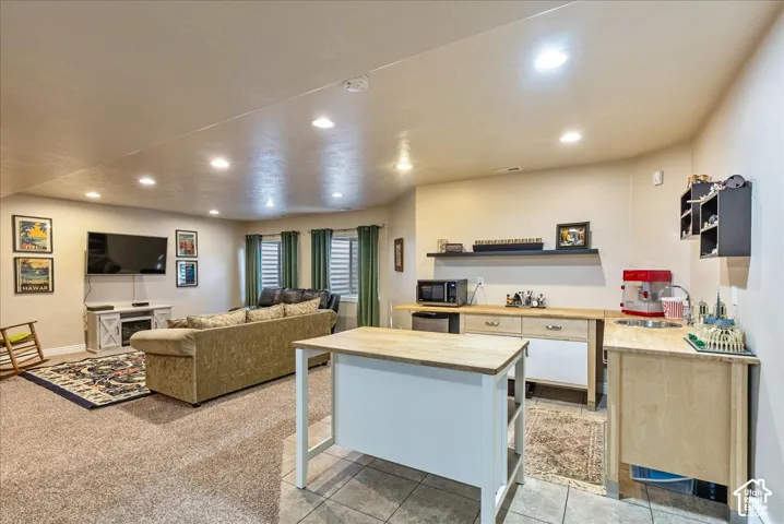 Recessed lighting, wood-finish countertops, tiled flooring, built-in cabinetry, and integrated mini-fridge
