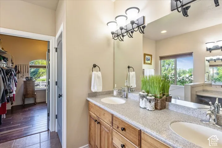 Dual undermount sinks with chrome fixtures, a stone-finish countertop, and wood cabinetry