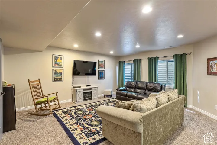Recessed ceiling lighting, light-toned wall finishes, carpeted flooring, and two egress windows