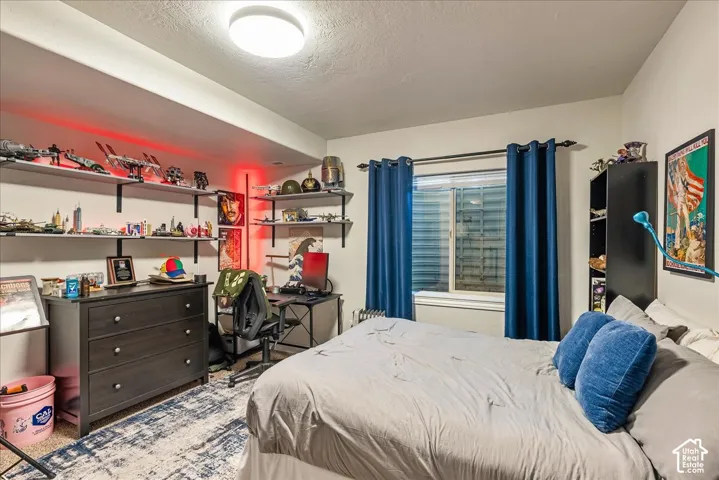 Recessed window with blue curtains and black rod, built-in wall shelving, and overhead flush-mount lighting