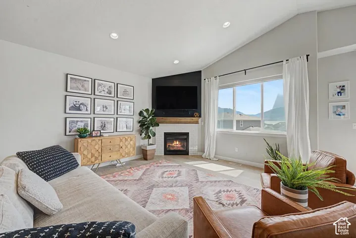 Living room featuring a fireplace with white tile surround, wood-finish mantel, and media wall