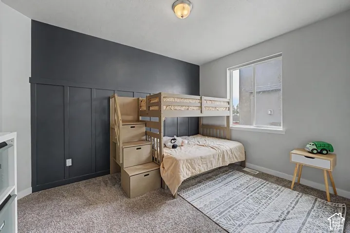Recessed ceiling light, board and batten accent wall, single window, light gray wall paint, and carpeted flooring