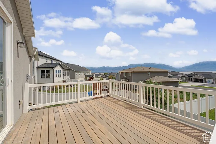 Expansive outdoor deck featuring wood-finish flooring and a white railing system