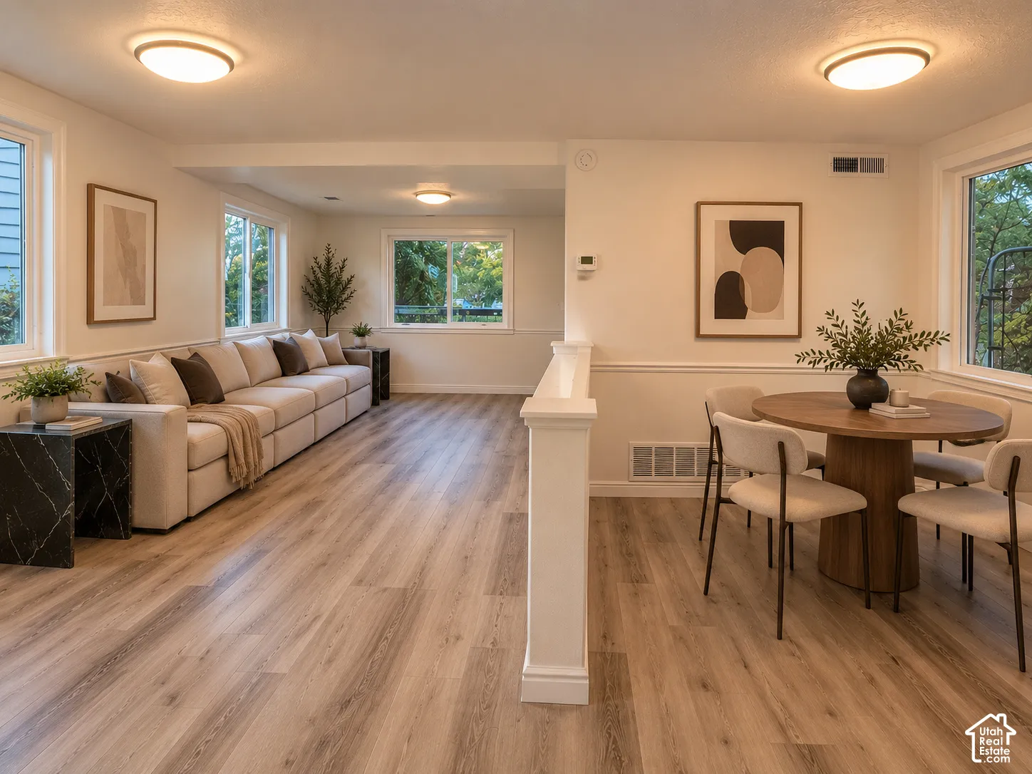 Spacious interior featuring wood-finish flooring, multiple windows, recessed ceiling lights, and white trim