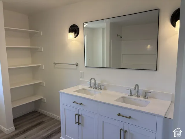 Double vanity with integrated sinks, quartz countertop, and white cabinetry