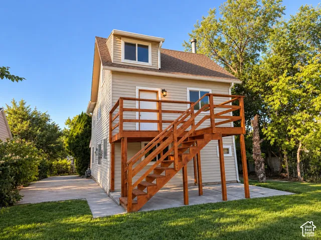 Siding exterior with a dormer window, complemented by a prominent wooden deck and staircase