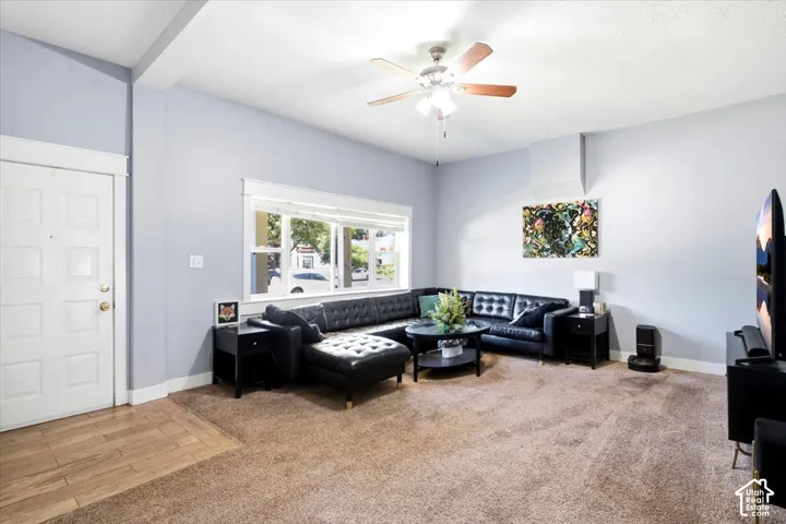 Spacious room featuring a ceiling fan, a large window, and light-colored walls