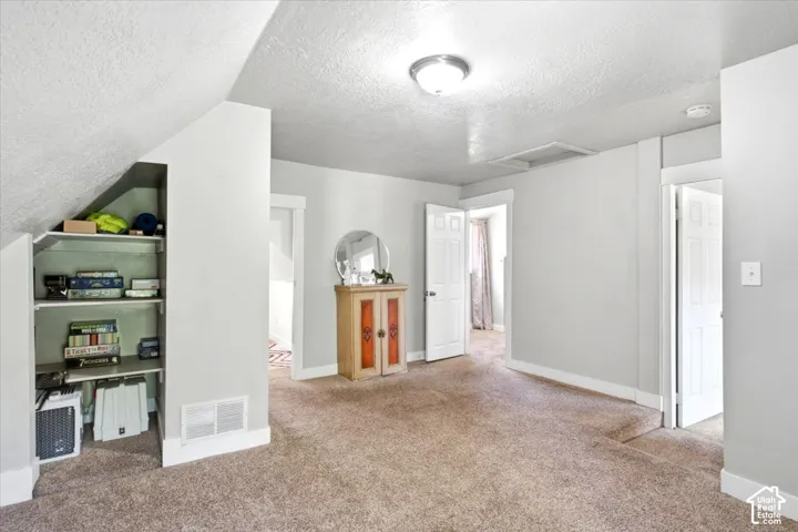 Carpeted room featuring built-in shelving, white trim, and light gray wall paint