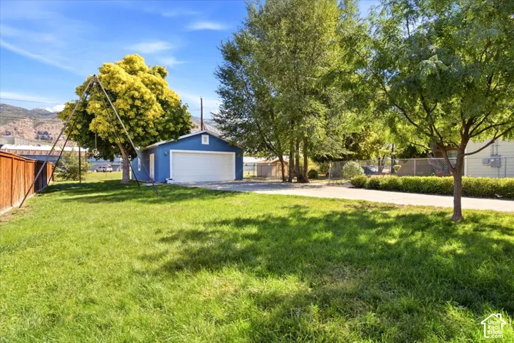 Detached garage featuring a white overhead door and blue siding