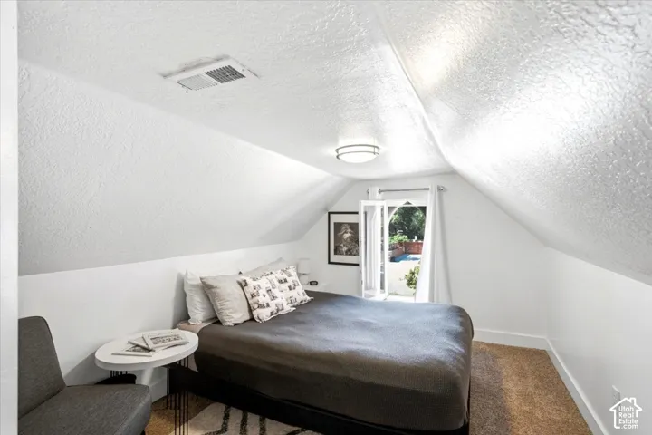 Angled ceilings with recessed wall panels, a window with white trim, and a modern ceiling light fixture