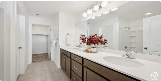 Dual vanity with undermount sinks, expansive mirror, and integrated lighting. This home is under construction. Pictures are of a similar home.