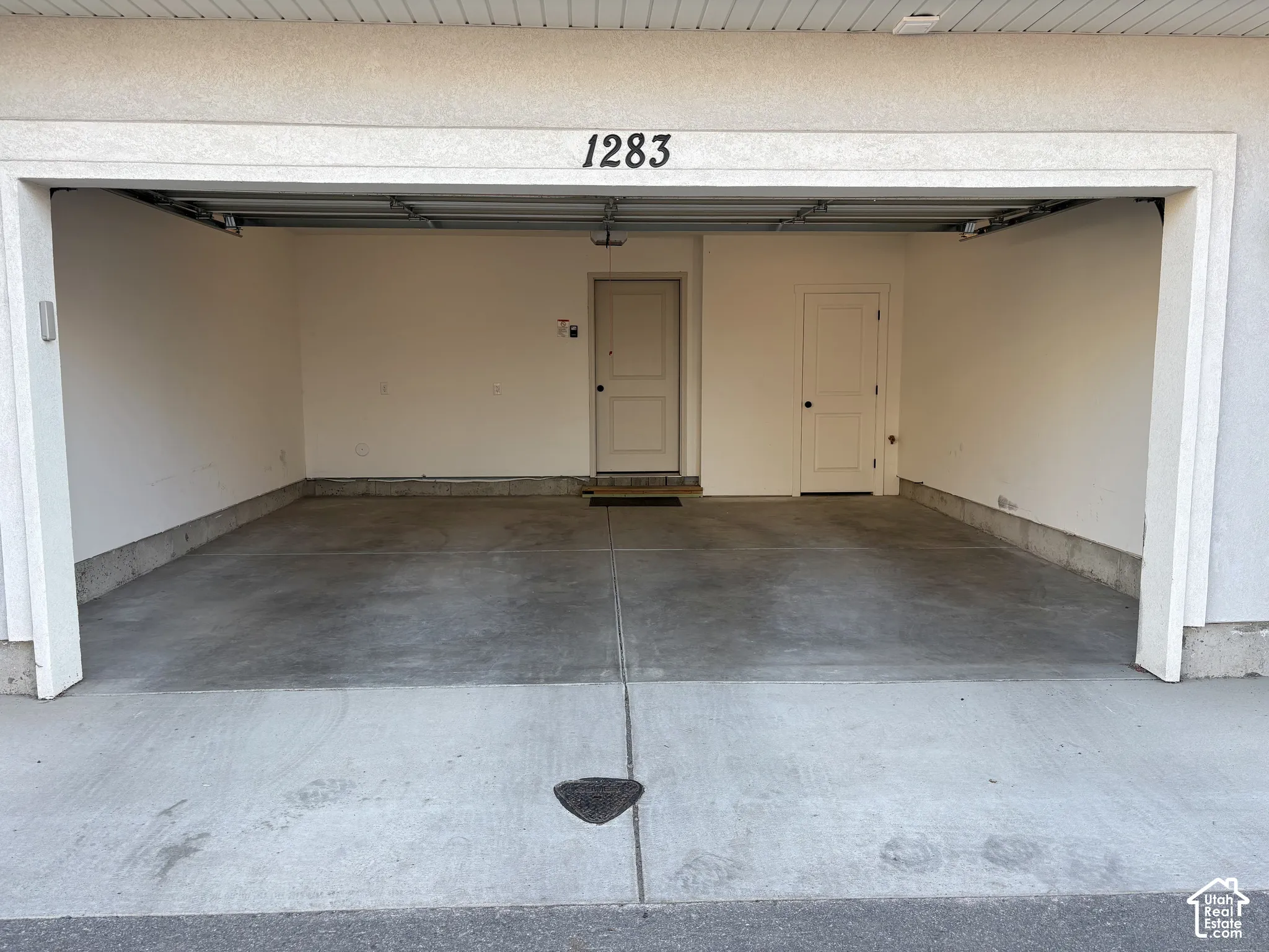 Attached garage with concrete flooring and direct interior access with garage door and keypad entry.