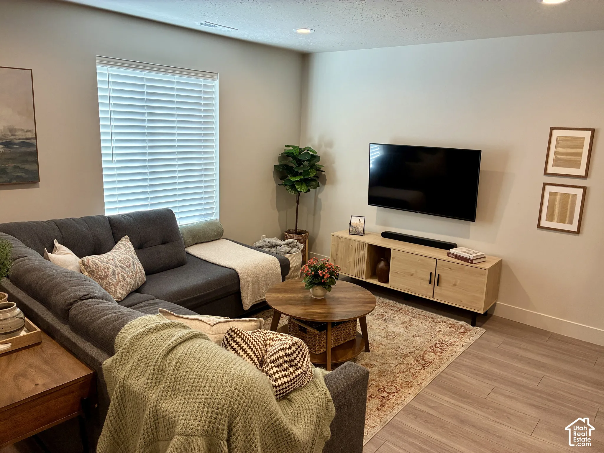 Recessed ceiling lighting, wood-finish flooring, and a window with horizontal blinds. Couch, TV, TV stand,  included*