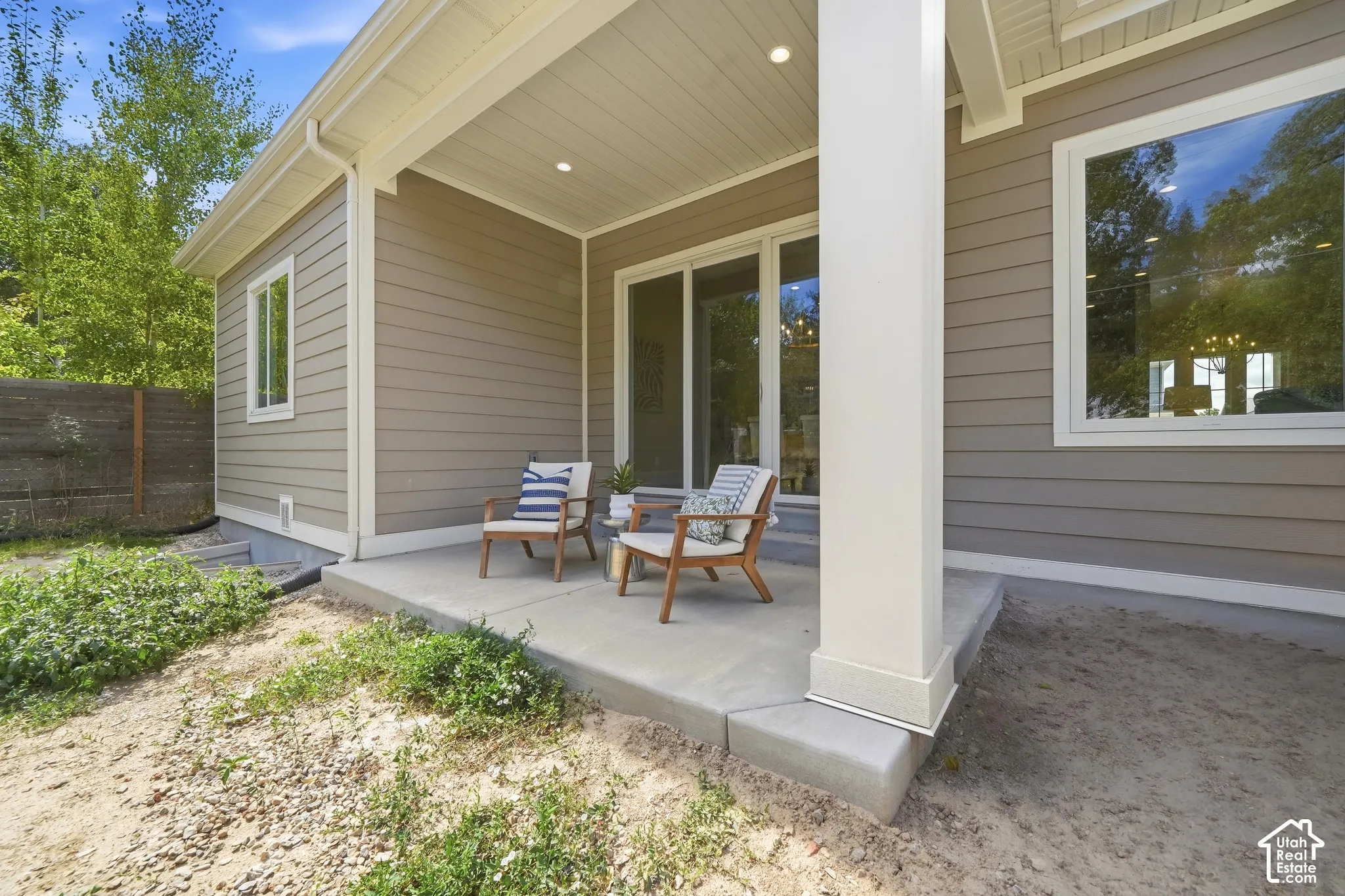 Covered concrete patio with recessed lighting, large windows, and sliding glass doors