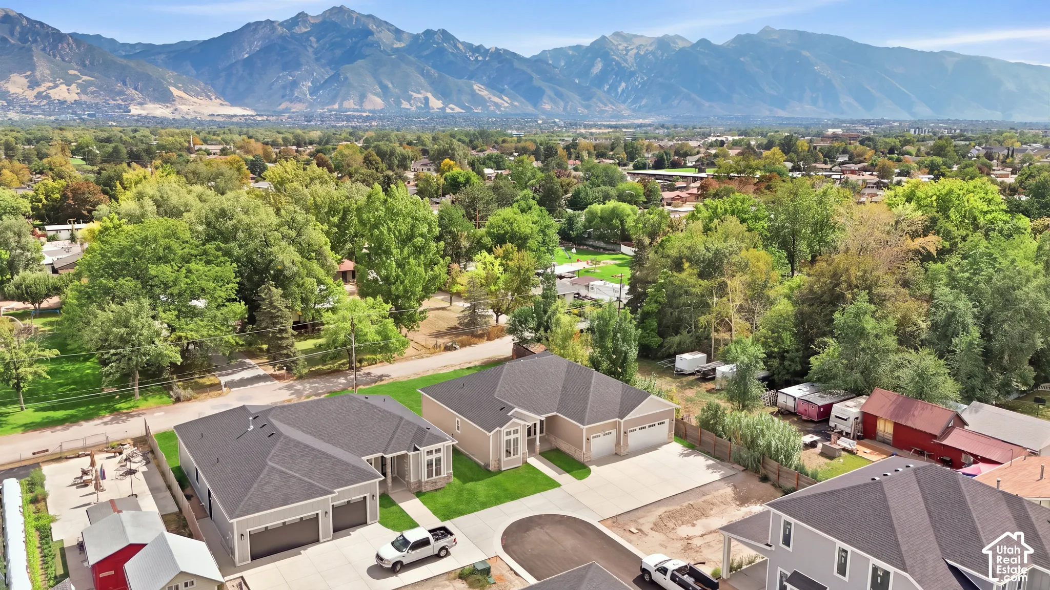 Residential development with newly constructed homes, paved driveways, and landscaped front yards