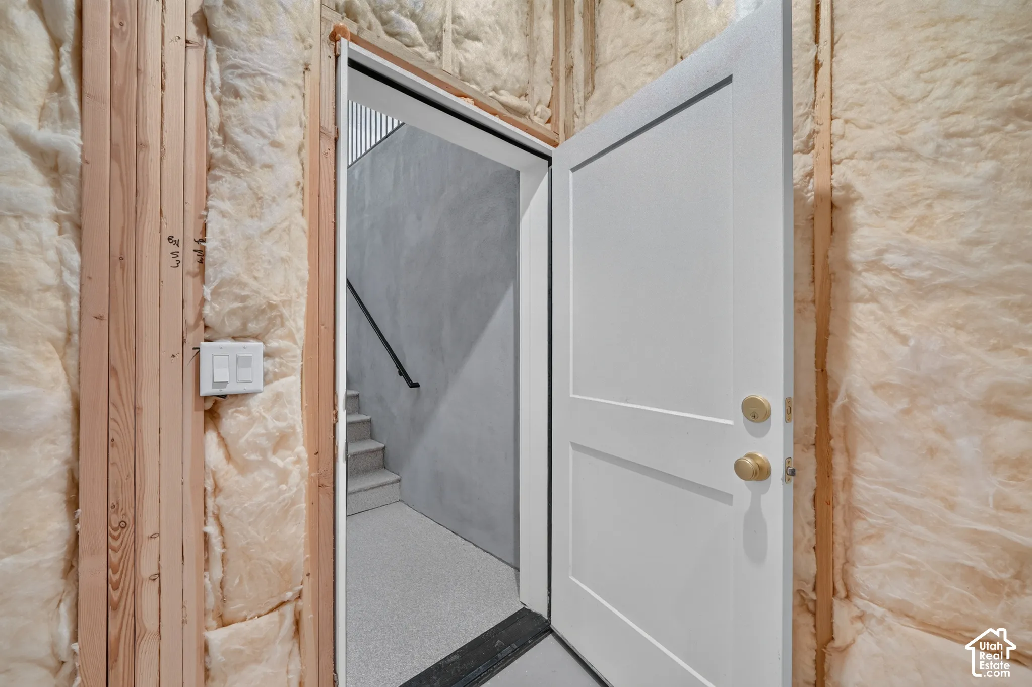 Unfinished wall featuring wood framing and insulation