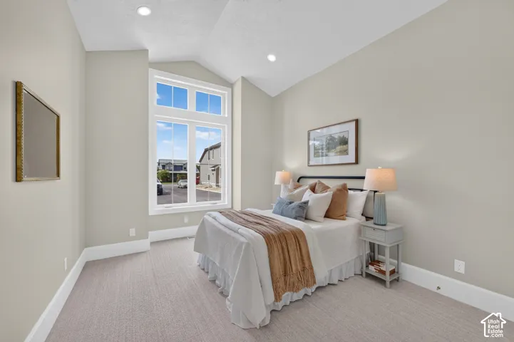 Vaulted ceiling, recessed lighting, expansive window, neutral wall tones, and light-colored carpeting