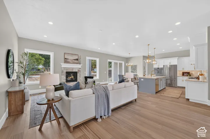 Expansive common area featuring wood-finish flooring, a stone-clad fireplace, and recessed lighting