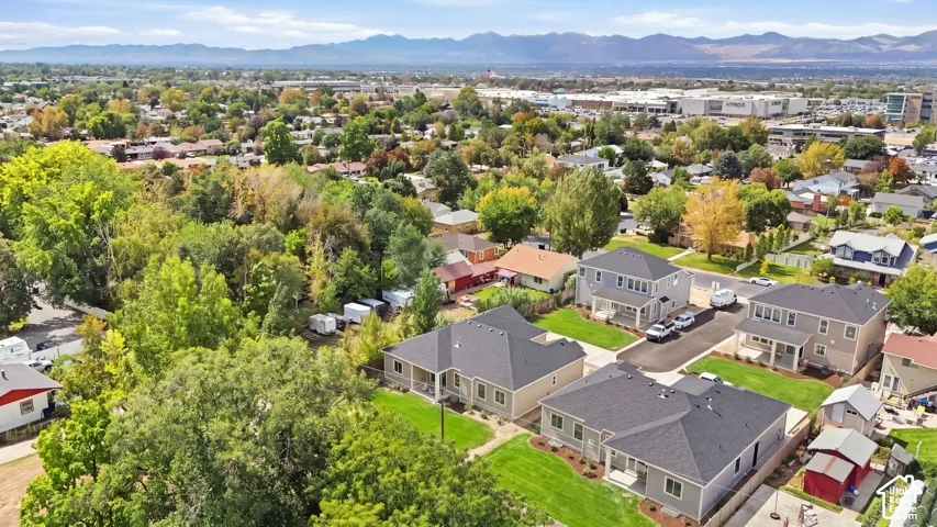 Residential area featuring mature trees, paved streets, and distant mountain ranges