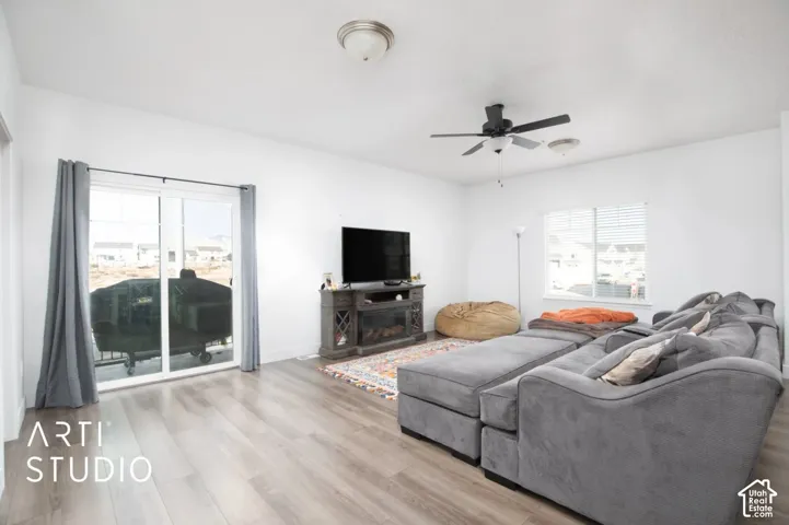 Sliding glass door, wood-finish flooring, ceiling fan, recessed lighting, and a window with blinds