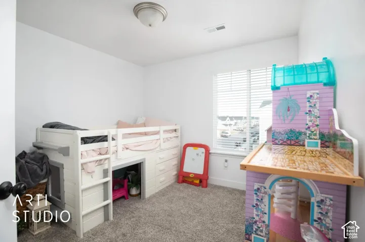 Carpeted room with a single window and ceiling-mounted light fixture