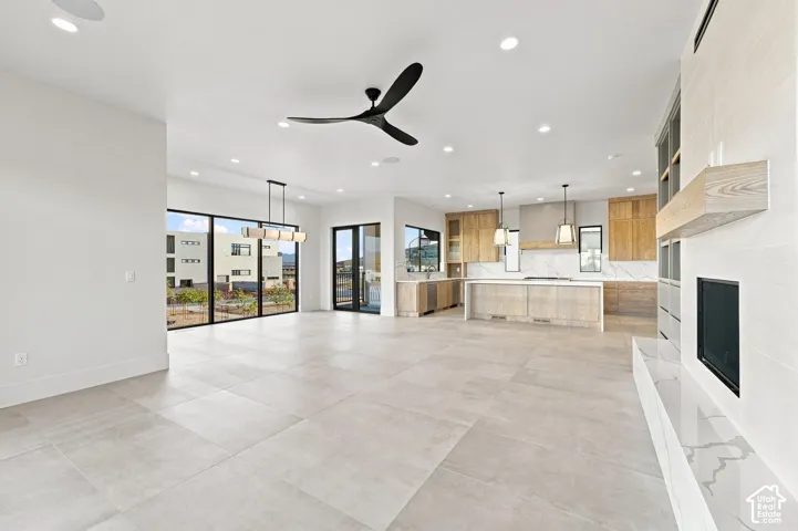 Spacious interior with large format tile flooring, modern fireplace, and recessed lighting