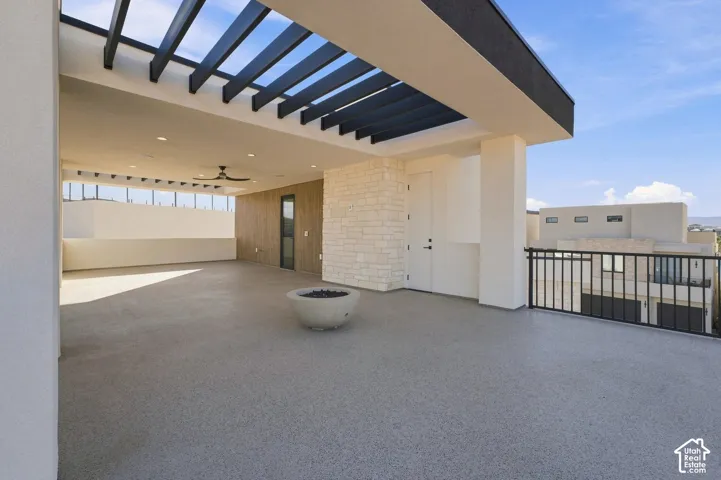Expansive outdoor terrace featuring a modern pergola, recessed lighting, and a ceiling fan