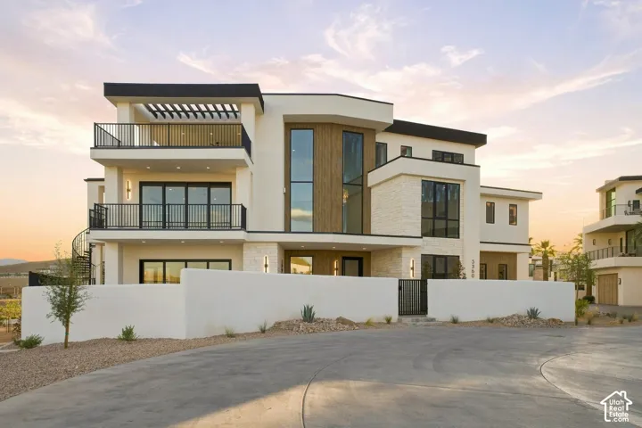 Modern architectural design featuring stacked balconies with black railings, a large vertical pane window, and wood-finish paneling accents