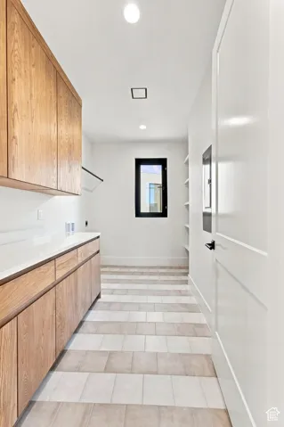 Light wood-finish cabinetry with white countertops