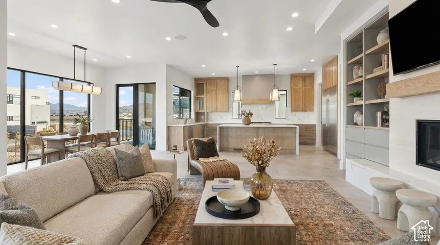 Open-concept living space with large format tile flooring, a built-in fireplace, and custom shelving