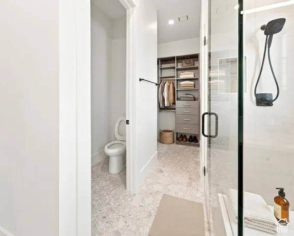Walk-in shower with a matte black shower system, floor-to-ceiling glass enclosure, and a built-in bench