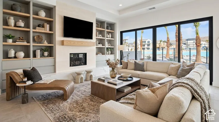 Built-in shelving units, integrated fireplace, large format sliding glass doors, and light-toned flooring