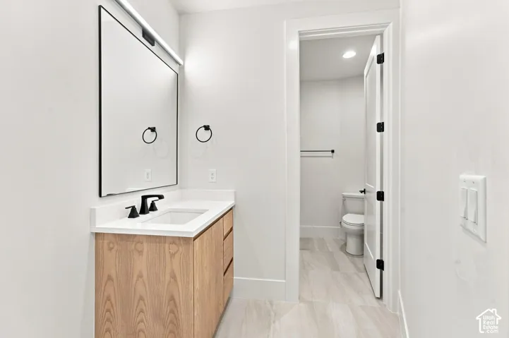 Wood-finish vanity with a white countertop and undermount sink
