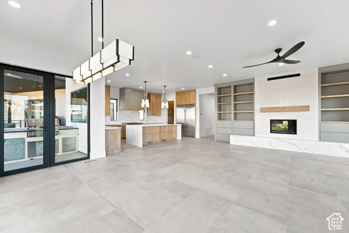 Open-concept living area with large format tile flooring and recessed lighting