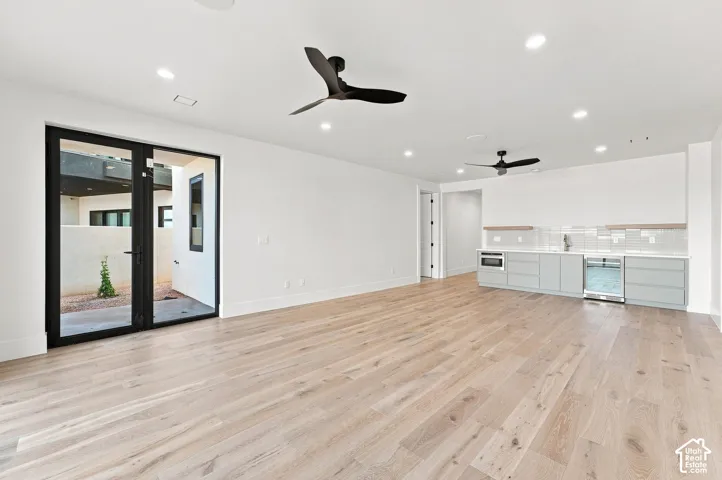 Light wood-finish flooring with a built-in wet bar featuring a beverage cooler and microwave