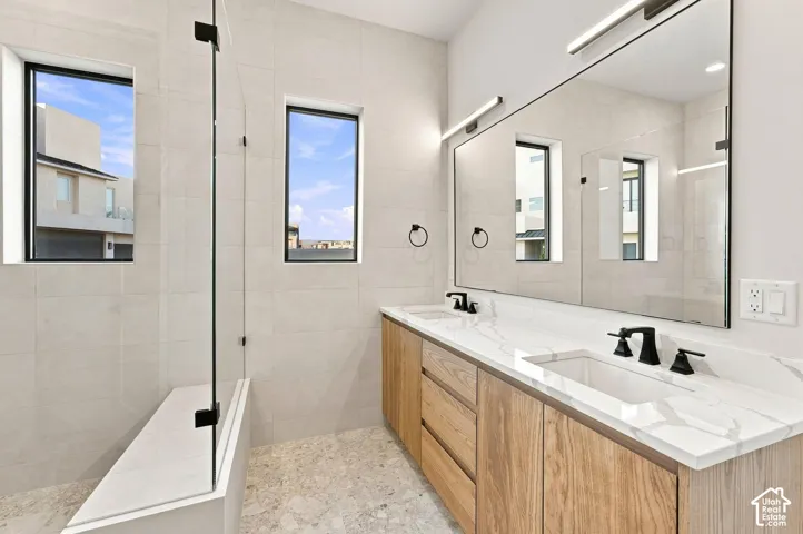 Dual vanity featuring wood-finish cabinetry and a stone countertop