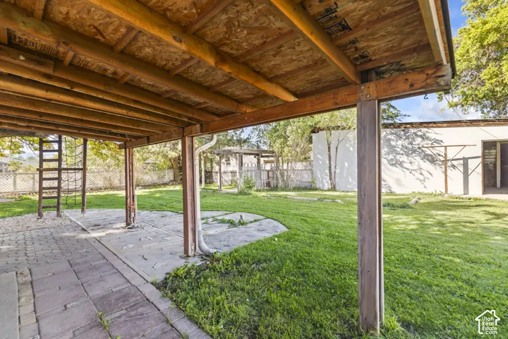 Covered patio with a concrete slab and wood beam supports