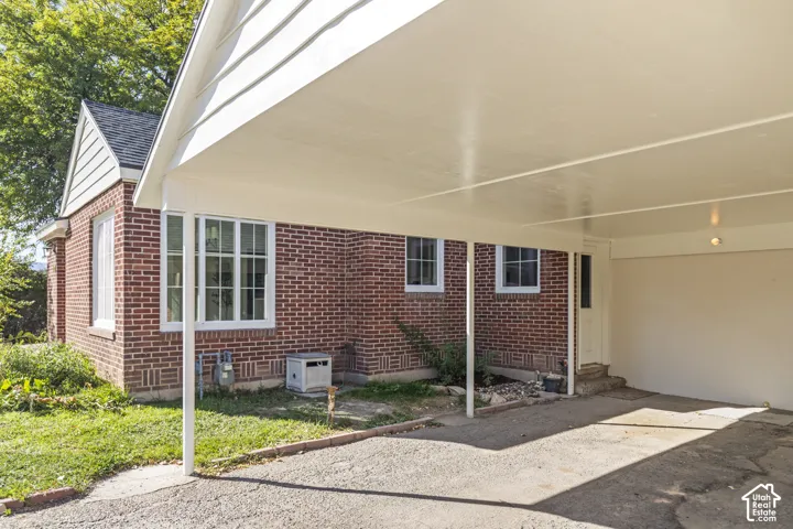 Exterior featuring a carport, brick facade, and multiple pane windows