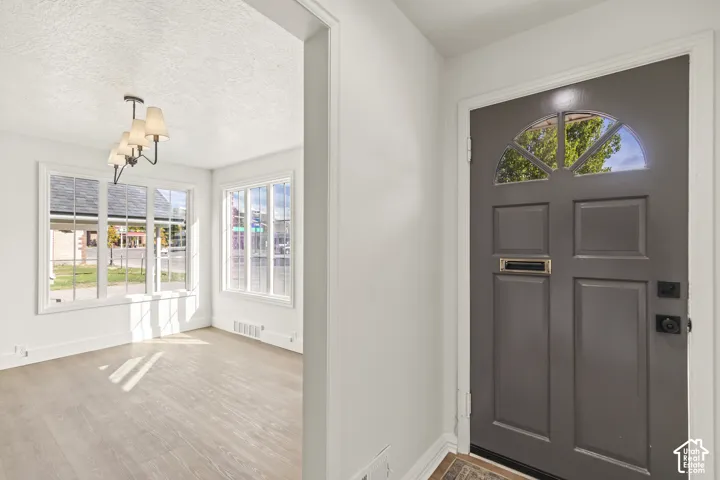 Entryway featuring a paneled door with a transom window and a brass mail slot