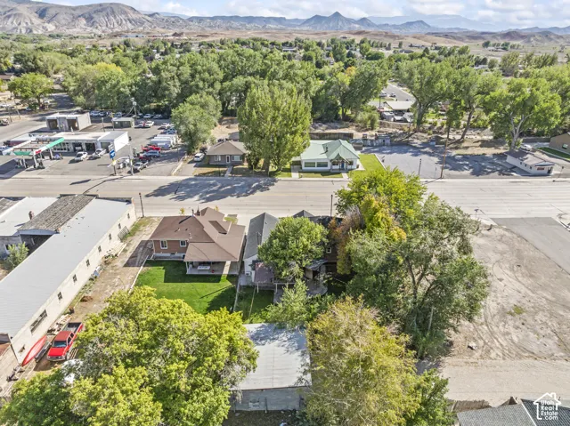 Spacious lot featuring a multi-story residence with a gabled roof and covered front porch, complemented by a manicured lawn and mature trees