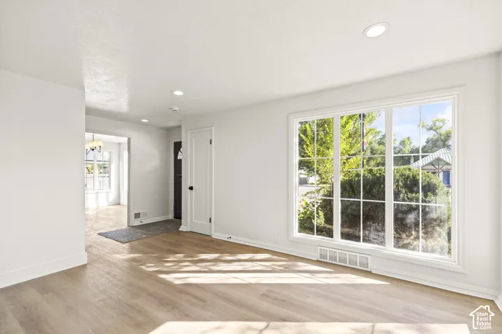 Bright interior with wood-finish flooring, recessed lighting, and a large multi-pane window